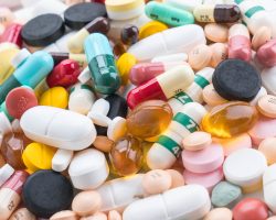 packings of pills and capsules of medicines on white background