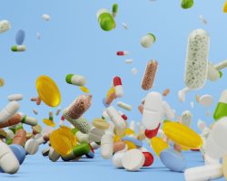 Many different colored tablets, capsules on blue background. Health care concept. Antibiotics inside pills, vitamins. Goods from the pharmacy. Pharmaceutical company, industry. 3d illustration
